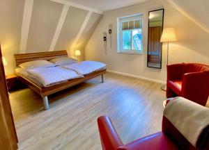 a bedroom with a bed and a red chair at Ferien auf der Burg in Niebüll