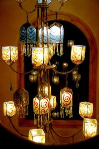 a chandelier with many lanterns in front of a mirror at Hosteria Cabañas Del Lago in Otavalo