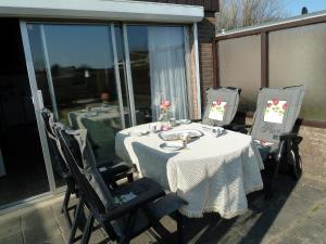 einen Tisch und Stühle auf einer Terrasse mit Tisch und Stühlen in der Unterkunft Vacation home Zwaantje #BL66 in Callantsoog