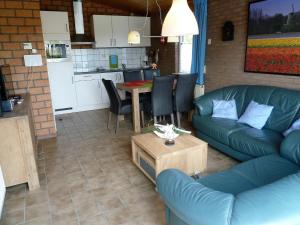 ein Wohnzimmer mit einem Sofa und einem Tisch in der Unterkunft Vacation home Zwaantje #BL66 in Callantsoog