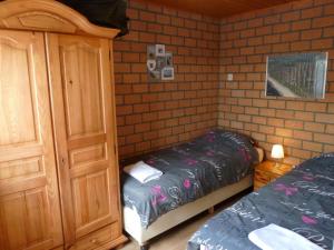 ein Schlafzimmer mit einem Bett neben einem Holzschrank in der Unterkunft Vacation home Zwaantje #BL66 in Callantsoog