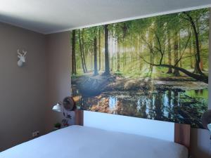 a bedroom with a painting of a forest at Ferienhaus Hunolstein in Morbach