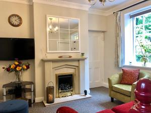 ein Wohnzimmer mit Kamin und Fernseher in der Unterkunft Ewood Cottage *NEW* Exquisite Country Cottage in Todmorden