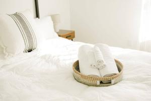 - un panier en osier avec des serviettes sur le lit dans l'établissement Burnett Cottage - Pine, à Cedar Rapids