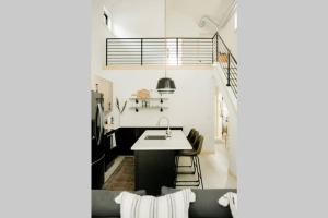 uma cozinha com um lavatório e uma mesa num quarto em Burnett Cottage - Pine em Cedar Rapids