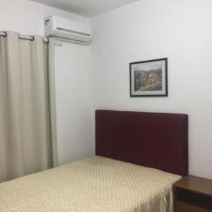 1 dormitorio con 1 cama y aire acondicionado en Pousada Alessandra, en Bombinhas