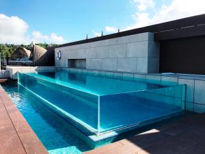 una piscina con acqua blu di fronte a un edificio di InterContinental Barcelona, an IHG Hotel a Barcellona