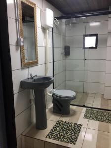 y baño con lavabo, aseo y espejo. en Pousada Alessandra, en Bombinhas