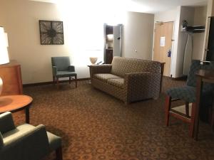 uma sala de estar com um sofá e cadeiras num quarto em Holiday Inn Express and Suites St. Cloud, an IHG Hotel em Saint Cloud