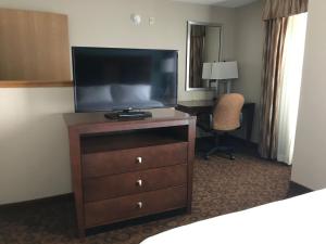 einen Fernseher auf einer Kommode in einem Hotelzimmer in der Unterkunft Holiday Inn Express and Suites St. Cloud, an IHG Hotel in Saint Cloud