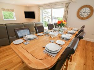 a dining room with a large wooden table and chairs at Beck View in Kendal