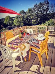 una mesa y sillas en una terraza de madera en cararetro , caravane chauffée et climatisée, en Saint-Sylvain-Bellegarde