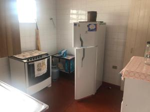 a kitchen with a stove and a white refrigerator at Casa na Enseada in Guarujá