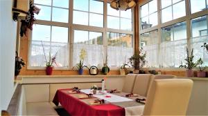 a dining room with a table and chairs and windows at Hochfilz´ner Hof in Hochfilzen