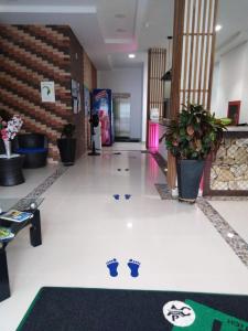 a lobby with a hallway with plants andcriptions on the floor at Hotel Aguazul Plaza Centro in Aguazul