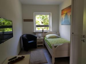 Schlafzimmer mit einem Bett, einem Schreibtisch und einem Fenster in der Unterkunft Fewo Daisy 195 in Wilhelmshaven