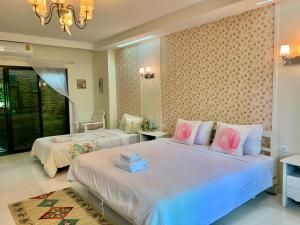 1 Schlafzimmer mit 2 Betten und rosa Kissen in der Unterkunft Nan Rim Nam Resort in Nan