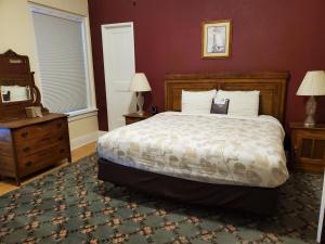 Schlafzimmer mit einem Bett, einer Kommode und einem Spiegel in der Unterkunft Manresa Castle in Port Townsend