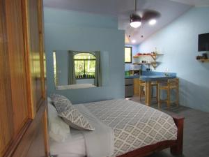 a bedroom with a bed and a small kitchen at Peace of Paradise in Manuel Antonio