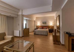 una camera d'albergo con un letto e un divano di Hotel Solans Riviera a Rosario