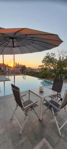 two chairs and a table with an umbrella at Casa do Vidoeiro in Seia