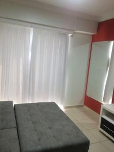um quarto com uma cama e uma cortina branca em Águas da Serra Apart Service 728A em Rio Quente