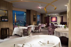 a restaurant with tables and chairs and a view of the eiffel tower at ANA InterContinental Tokyo, an IHG Hotel in Tokyo