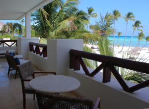 a patio area with chairs, tables and umbrellas at Secrets Cap Cana Resort & Spa - Adults Only in Punta Cana