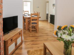 een woonkamer met een televisie en een eettafel bij Laridae in Whitby