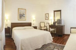 Villa Crispi في ميستر: غرفة نوم بسرير ومكتب وتلفزيون