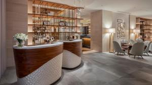 a bar in a restaurant with a table and chairs at ANA InterContinental Manza Beach Resort by IHG in Onna