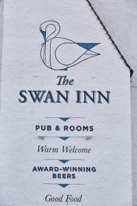 
a sign on a building with a picture of a man on it at The Swan Inn in Winscombe
