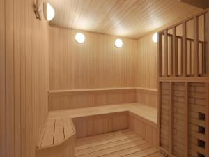a sauna with wood paneling and two lights in it at ANA InterContinental Manza Beach Resort by IHG in Onna