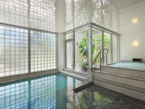 an indoor swimming pool with windows and a swimming poolvisorvisor at ANA InterContinental Manza Beach Resort by IHG in Onna