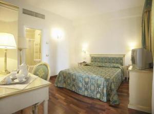 Habitación de hotel con cama y mesa con TV en Villa Crispi, en Mestre