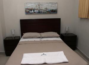 Un dormitorio con una cama con toallas blancas. en Estancia Real en Piura