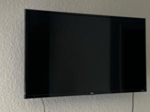 TV de pantalla plana colgada en la pared en Budget Inn Motel, en Austin