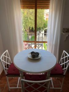una mesa blanca con dos sillas y un plato de fruta. en Apartamento Ocuri en Benaocaz