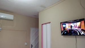 a flat screen tv hanging on a wall at Pousada Solar di Poletti in Nísia Floresta +15 photos