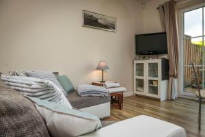 ein Wohnzimmer mit einem Sofa und einem TV in der Unterkunft Ferienwohnung Heide View in Bispingen