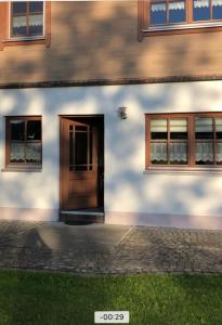 un edificio con puerta de madera y 2 ventanas en Ostallgäu, en Ruderatshofen