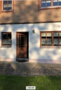 a building with a wooden door and two windows at Ostallgäu in Ruderatshofen +5 photos
