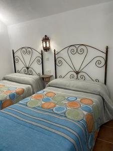 two beds in a room with two lamps on top of them at Cueva El Jaraiz in Guadix