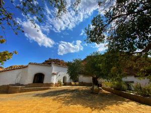 un bâtiment blanc avec un arbre devant lui dans l'établissement Cuevas Pedro Antonio de Alarcon, à Guadix