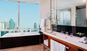 a bathroom with a large mirror and a large window at InterContinental Doha The City, an IHG Hotel in Doha
