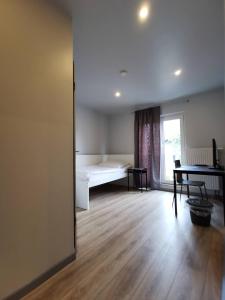 um quarto com uma cama, uma mesa e uma janela em Hotel Engelsburg - Apartments em Remscheid