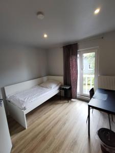 1 dormitorio con cama blanca y ventana en Hotel Engelsburg - Apartments, en Remscheid