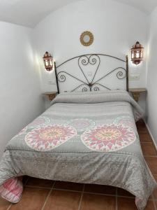 a bed with a white bedspread and pillows at Cueva El Jaraiz in Guadix