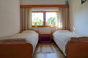 a bedroom with two beds and a window at Gospodarstwo Agroturystyczne LOBELIA in Pomysk Wielki