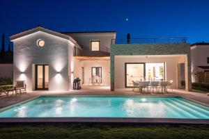 een villa met een zwembad in de nacht bij Ionian Trilogy Luxury Villas in Sami